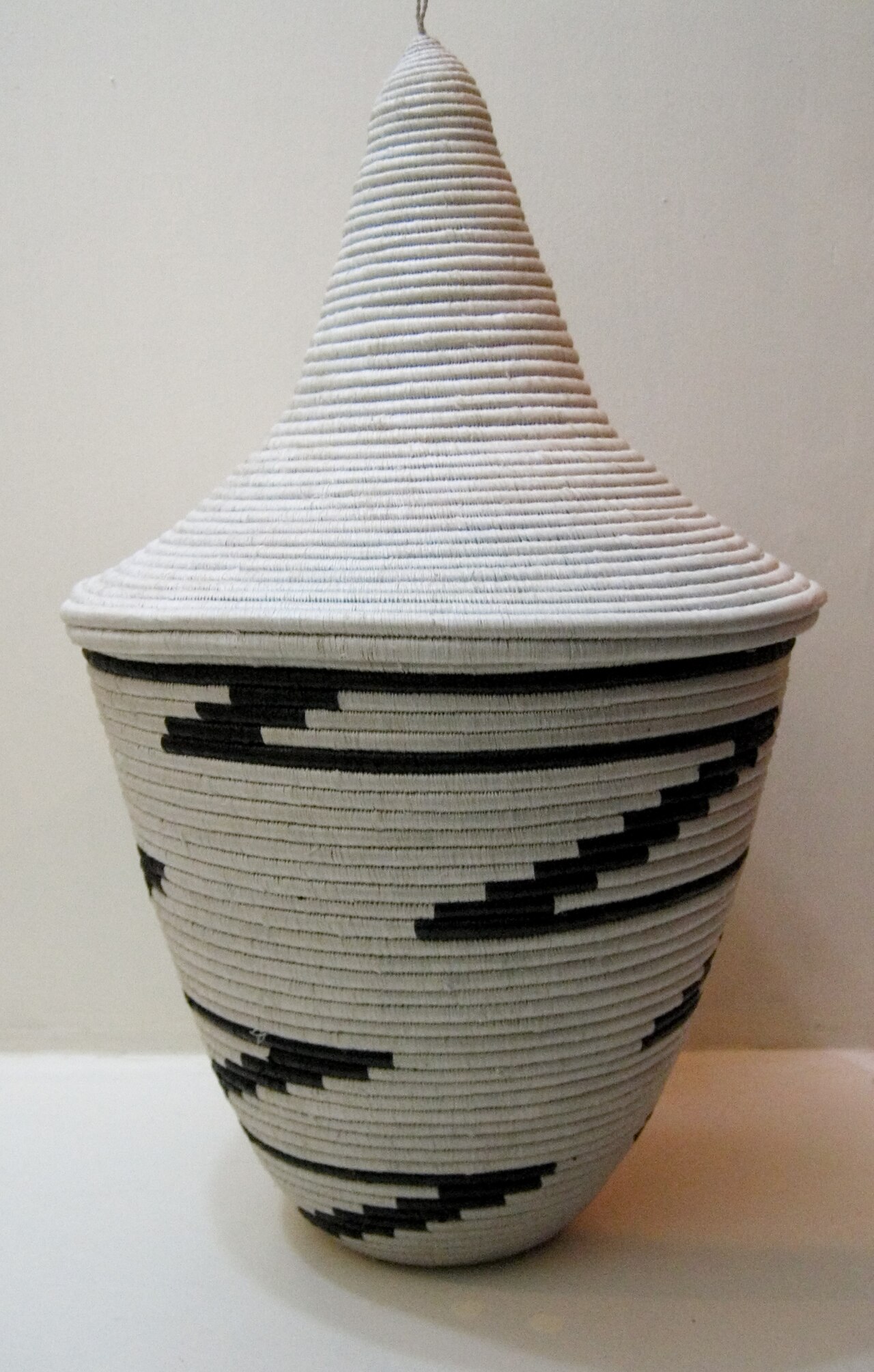 An igiseke, a finely woven Rwandan basket with its conical lid.