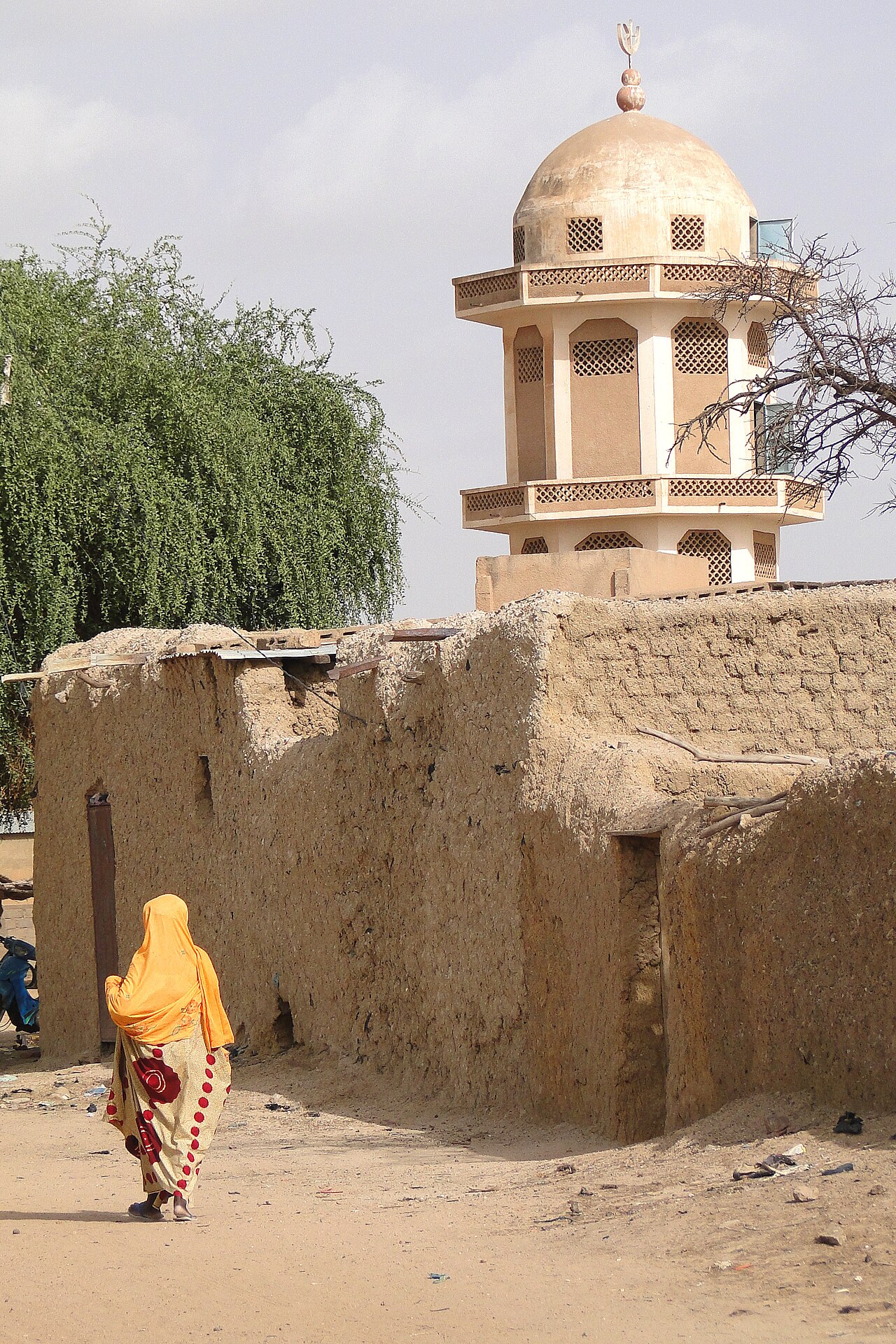A woman passing a mosque in the Sahel; the Zaghawa are Muslims.