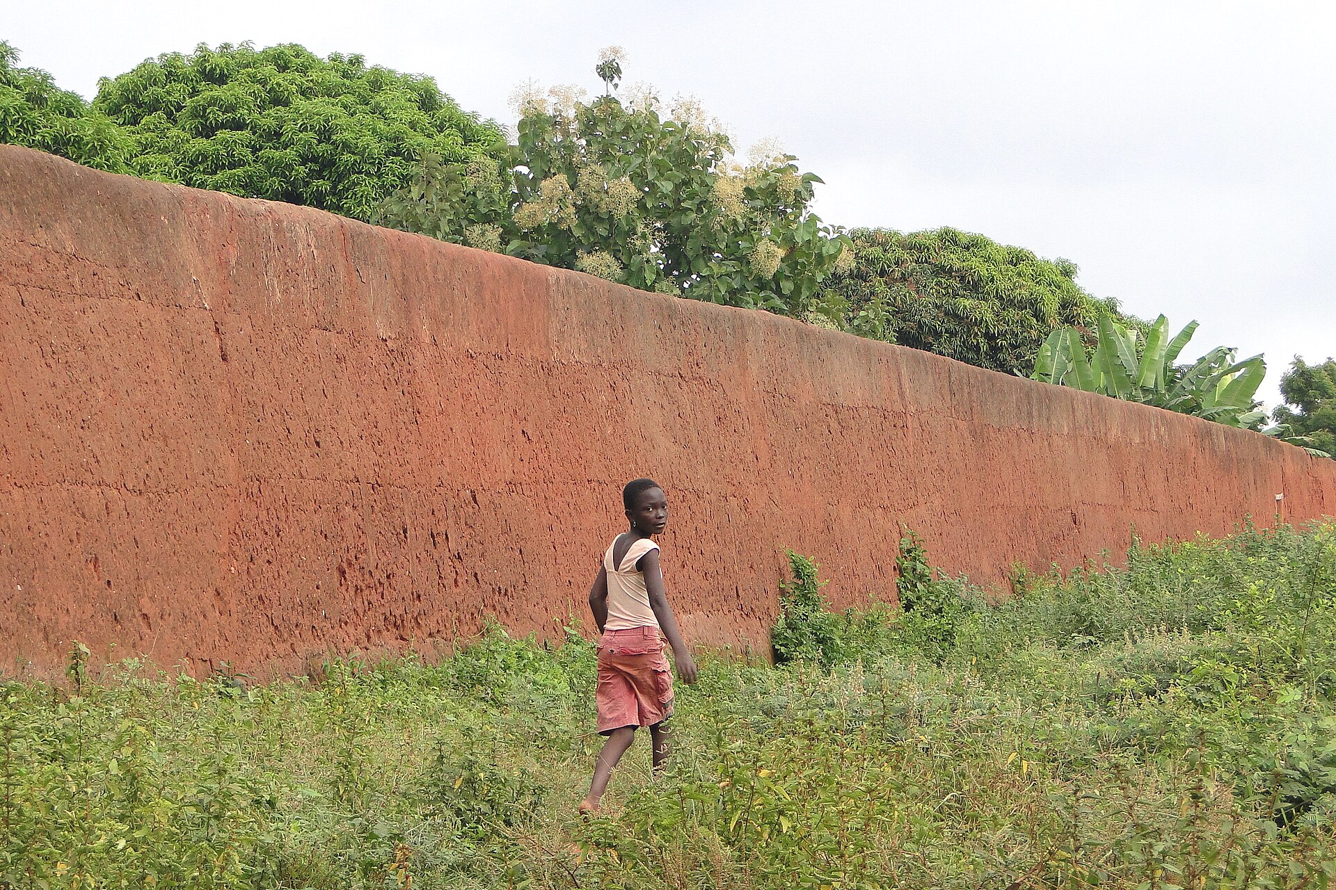 A girl walks past a palace wall at Abomey, where the royal city still stands.