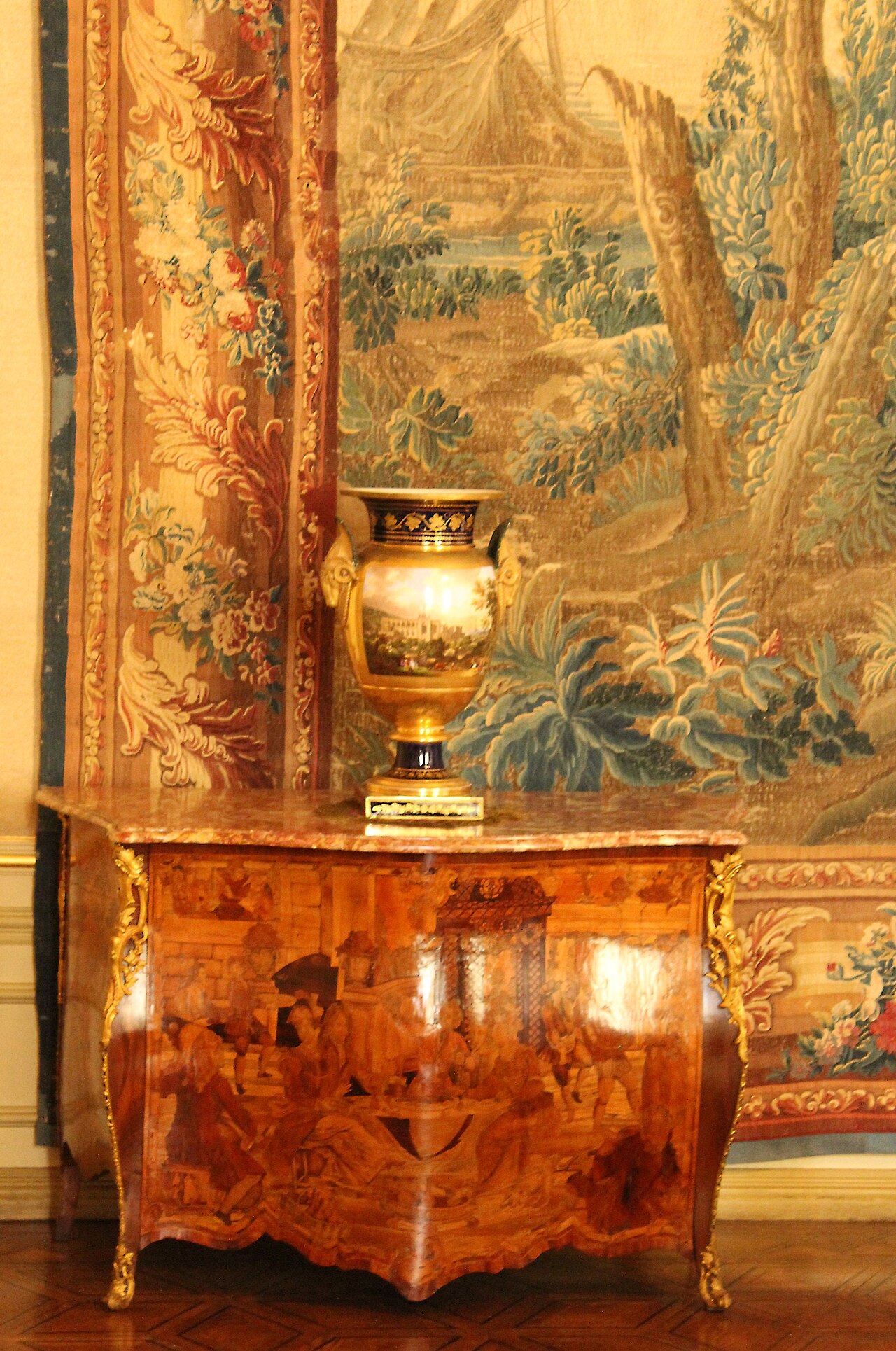 A commode, vase, and tapestry in one of the state rooms.