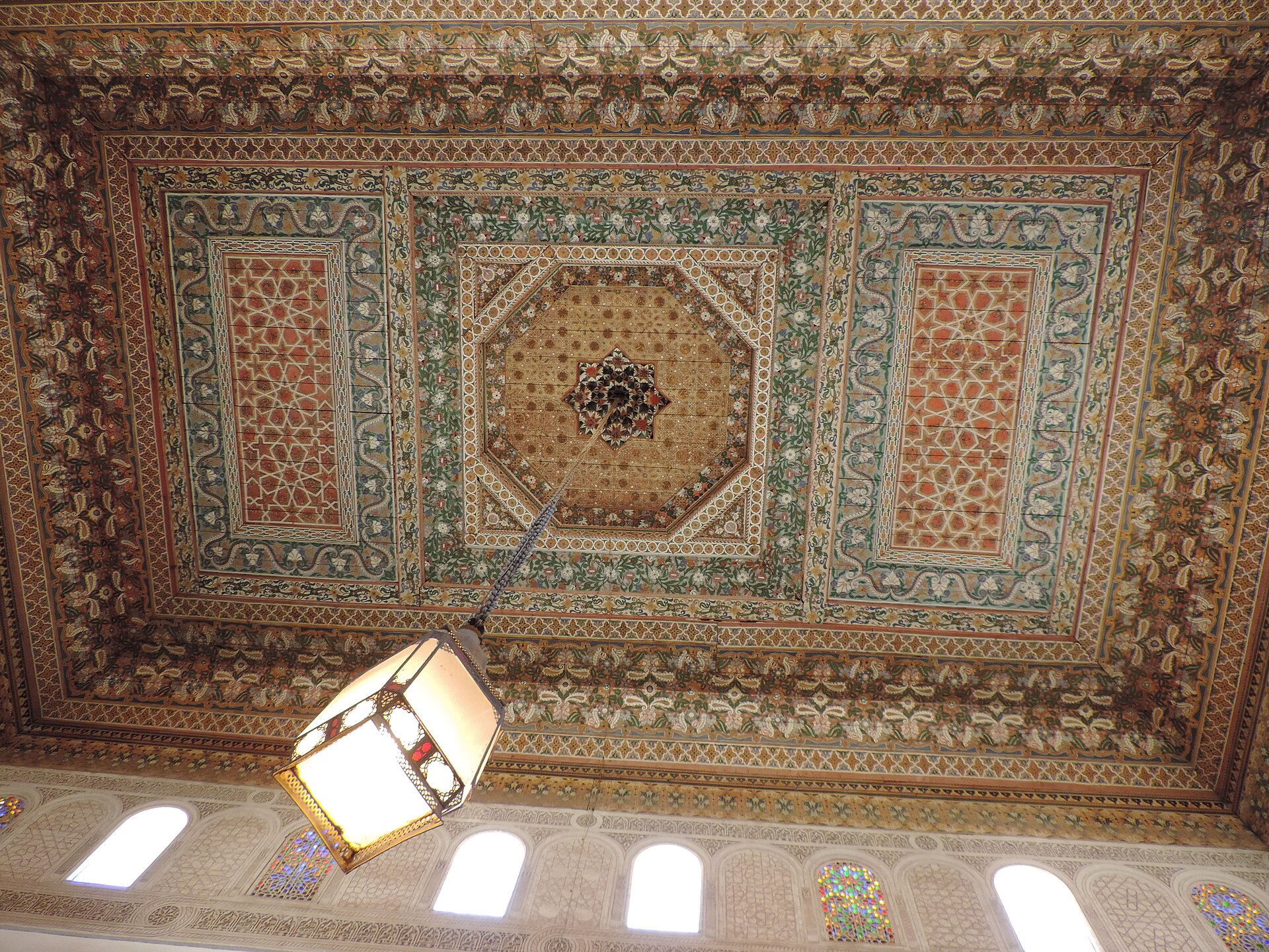 A painted cedar ceiling of the palace, glowing with intricate color and pattern.