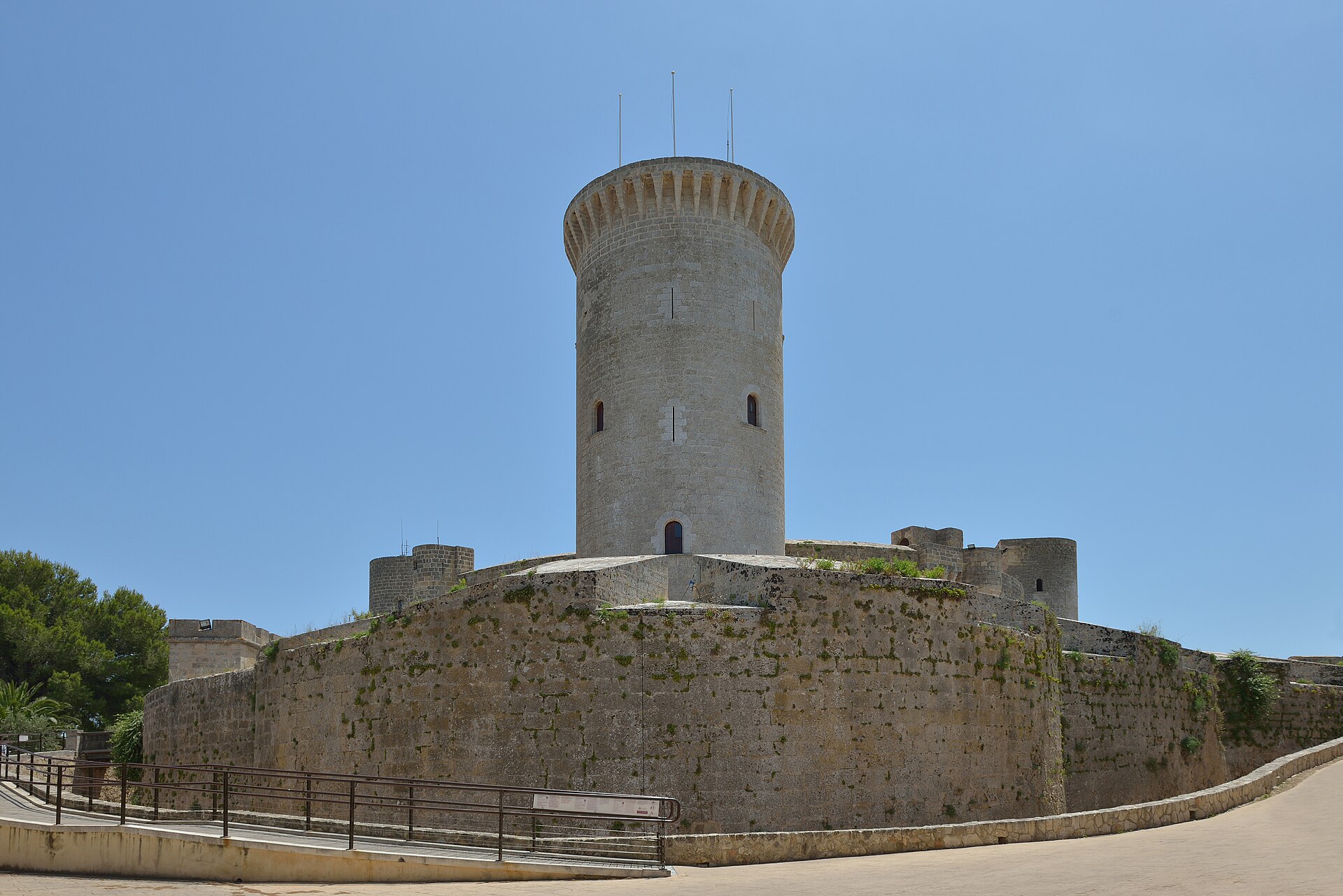 A tall free-standing keep rises apart from the ring, linked by a high bridge.
