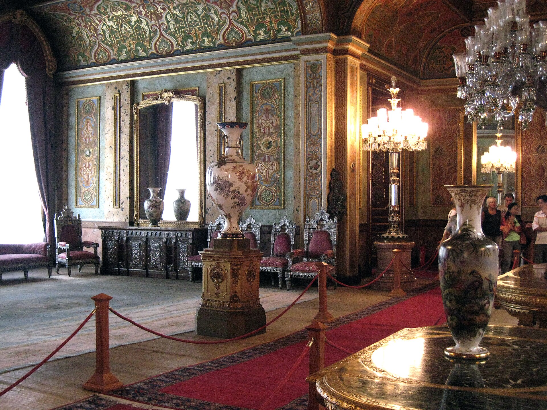 An opulent interior, decorated with crystal, carpets, and painted ceilings in the late Ottoman style.