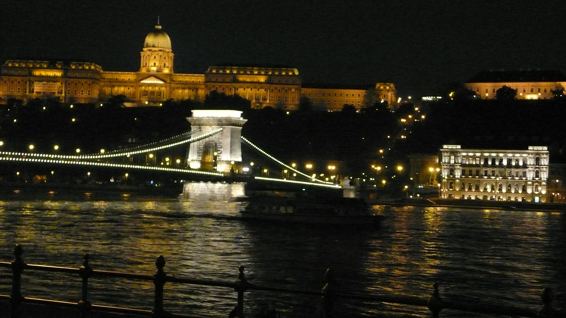 Buda Castle illuminated at night above the river