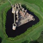 Caerlaverock Castle from the air, its unique triangular plan ringed by a broad moat in south-west Scotland
