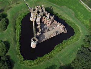 Caerlaverock Castle from the air, its unique triangular plan ringed by a broad moat in south-west Scotland