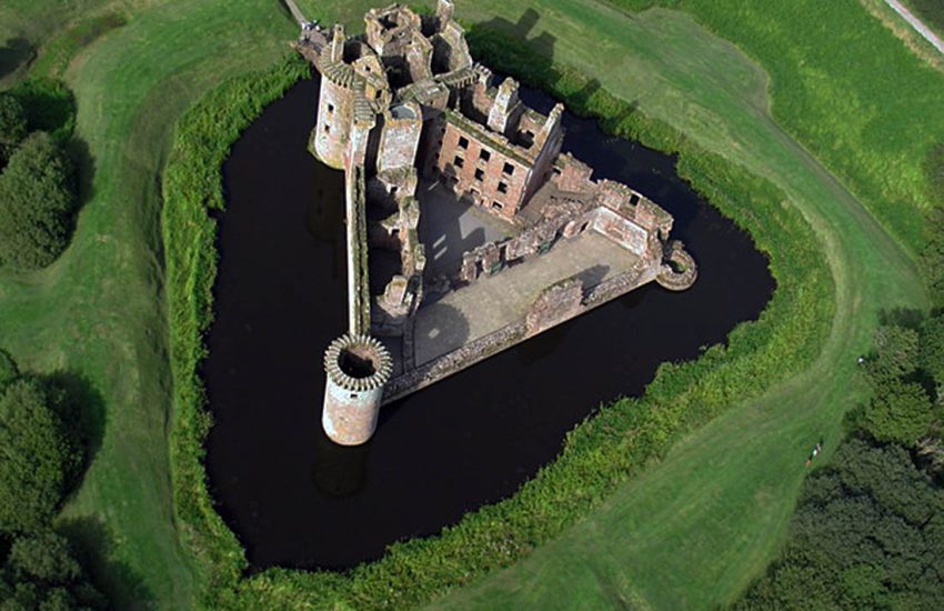 Caerlaverock Castle from the air, its unique triangular plan ringed by a broad moat in south-west Scotland