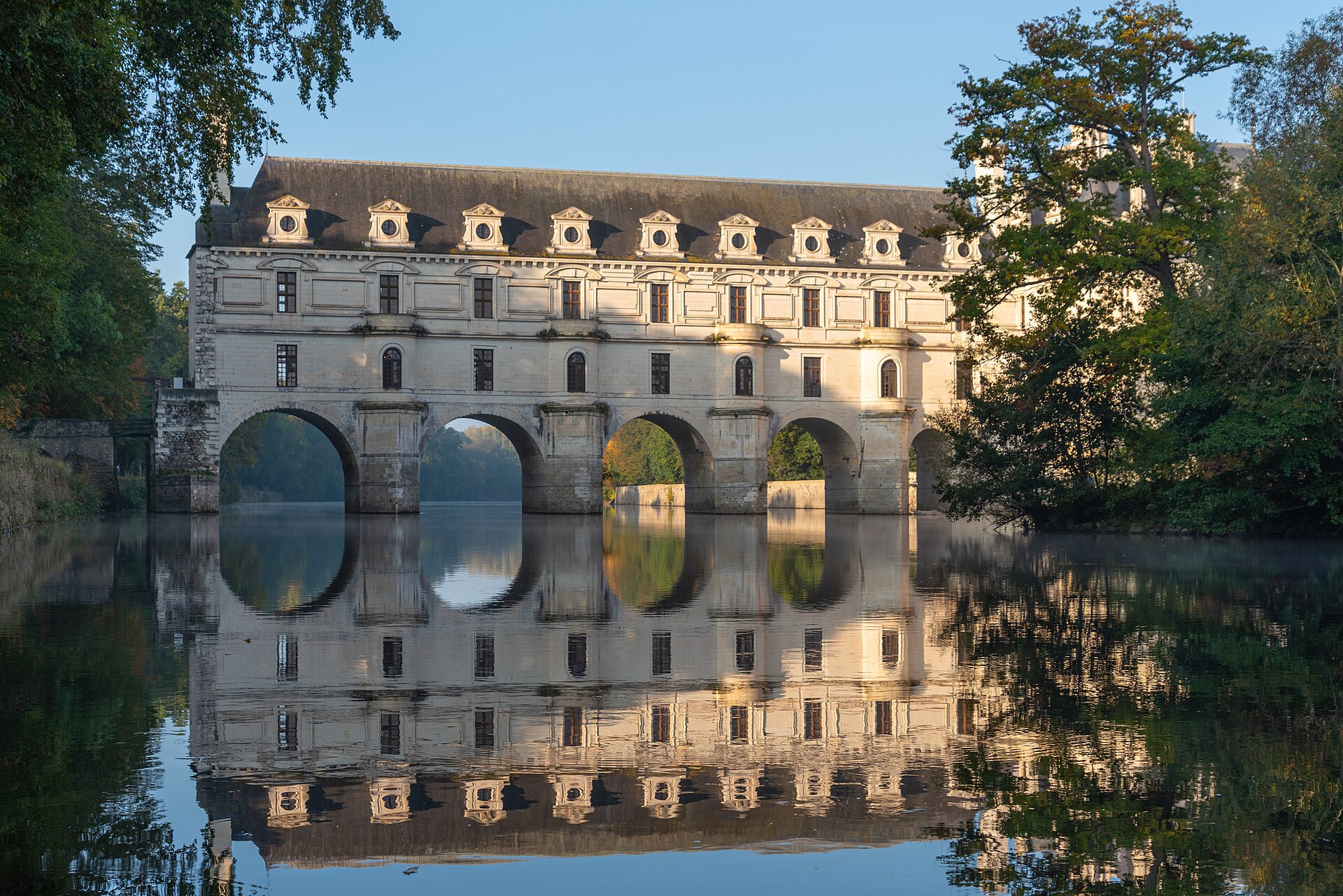The east facade of Chenonceau mirrored in the still waters of the Cher