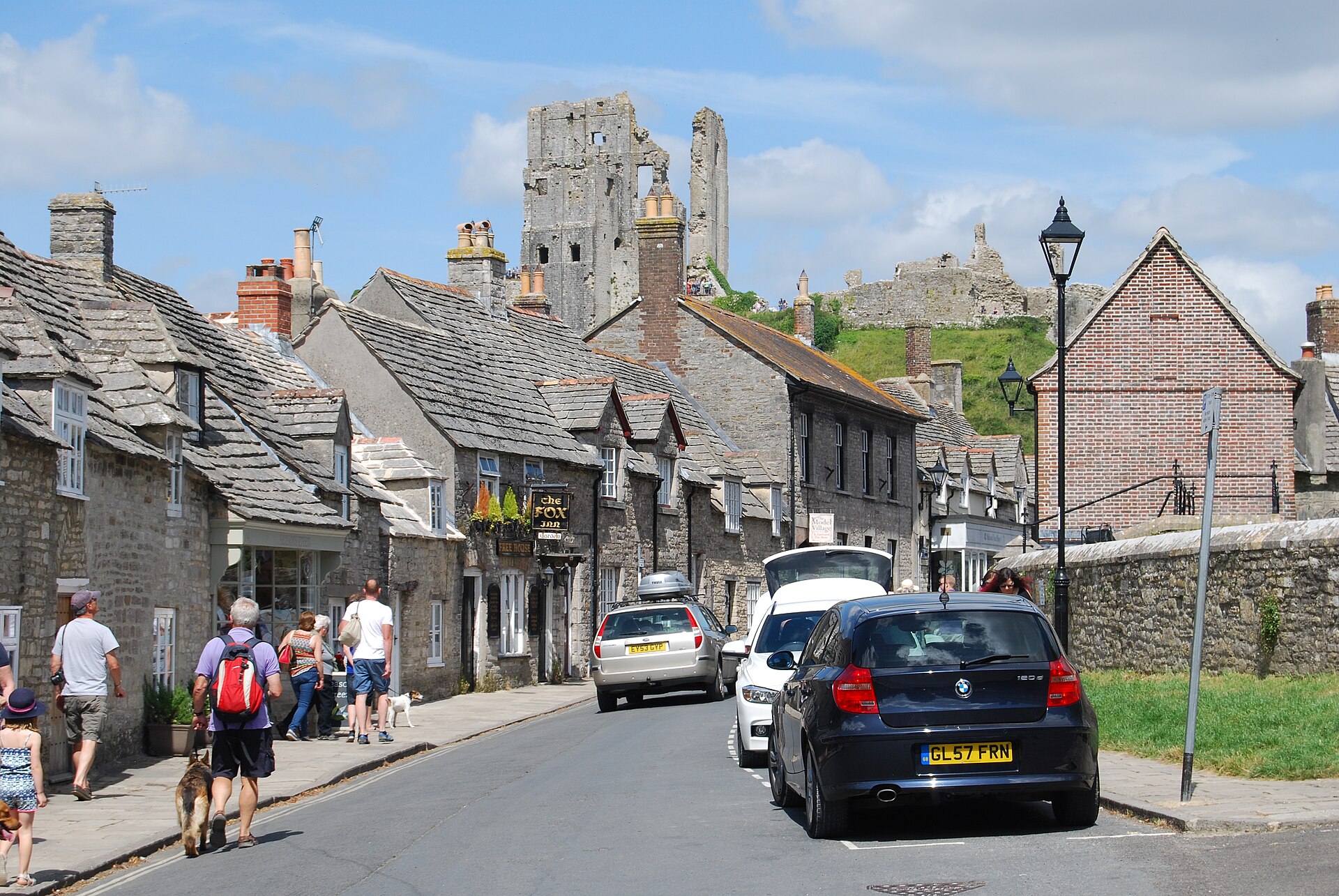 The stone village of Corfe Castle huddled at the foot of its dramatic ruin