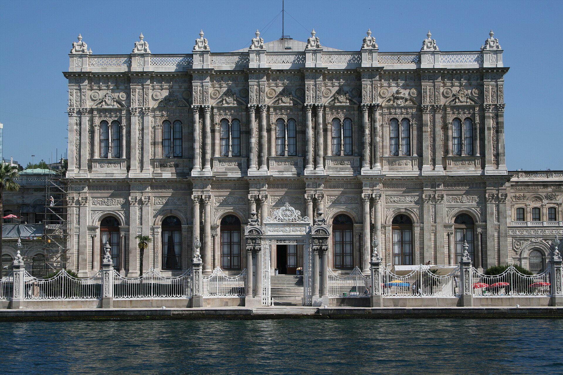 Dolmabahce Palace stretching along the Bosphorus, its long marble facade rising from the water's edge.
