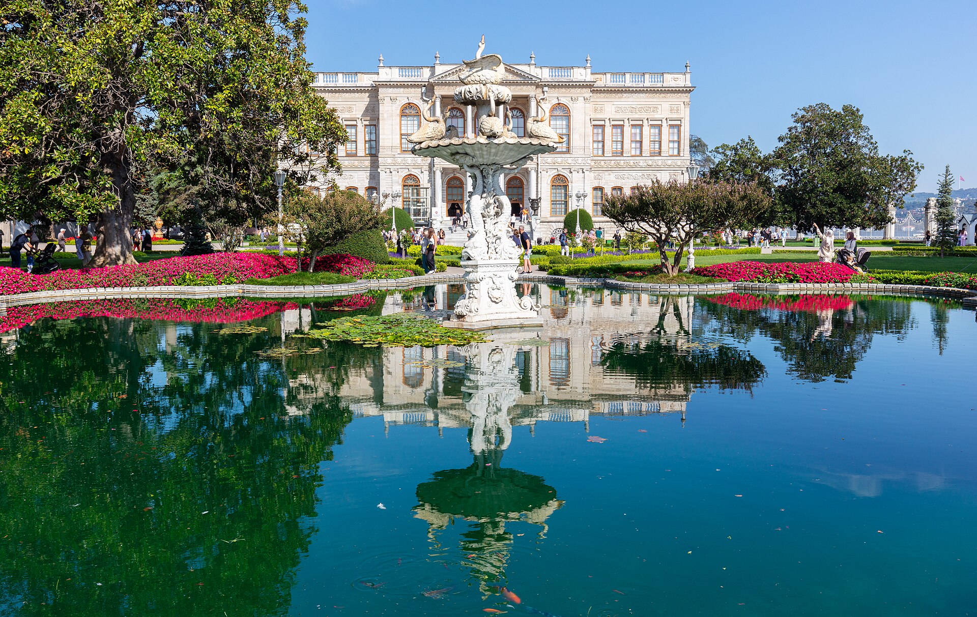 The white marble front of Dolmabahce against the blue of the Bosphorus and the surrounding hills.