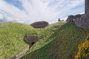 The castle's buildings clinging to the top of a great cliff, all but surrounded by the North Sea