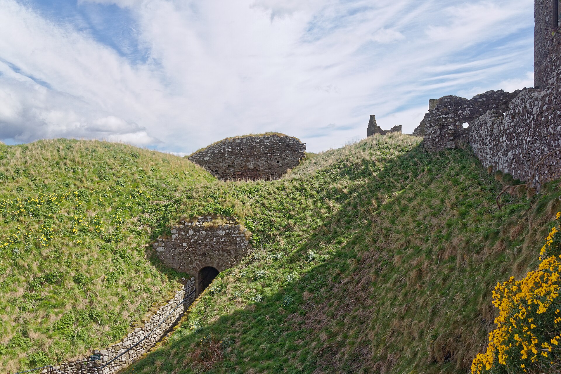 The castle's buildings clinging to the top of a great cliff, all but surrounded by the North Sea