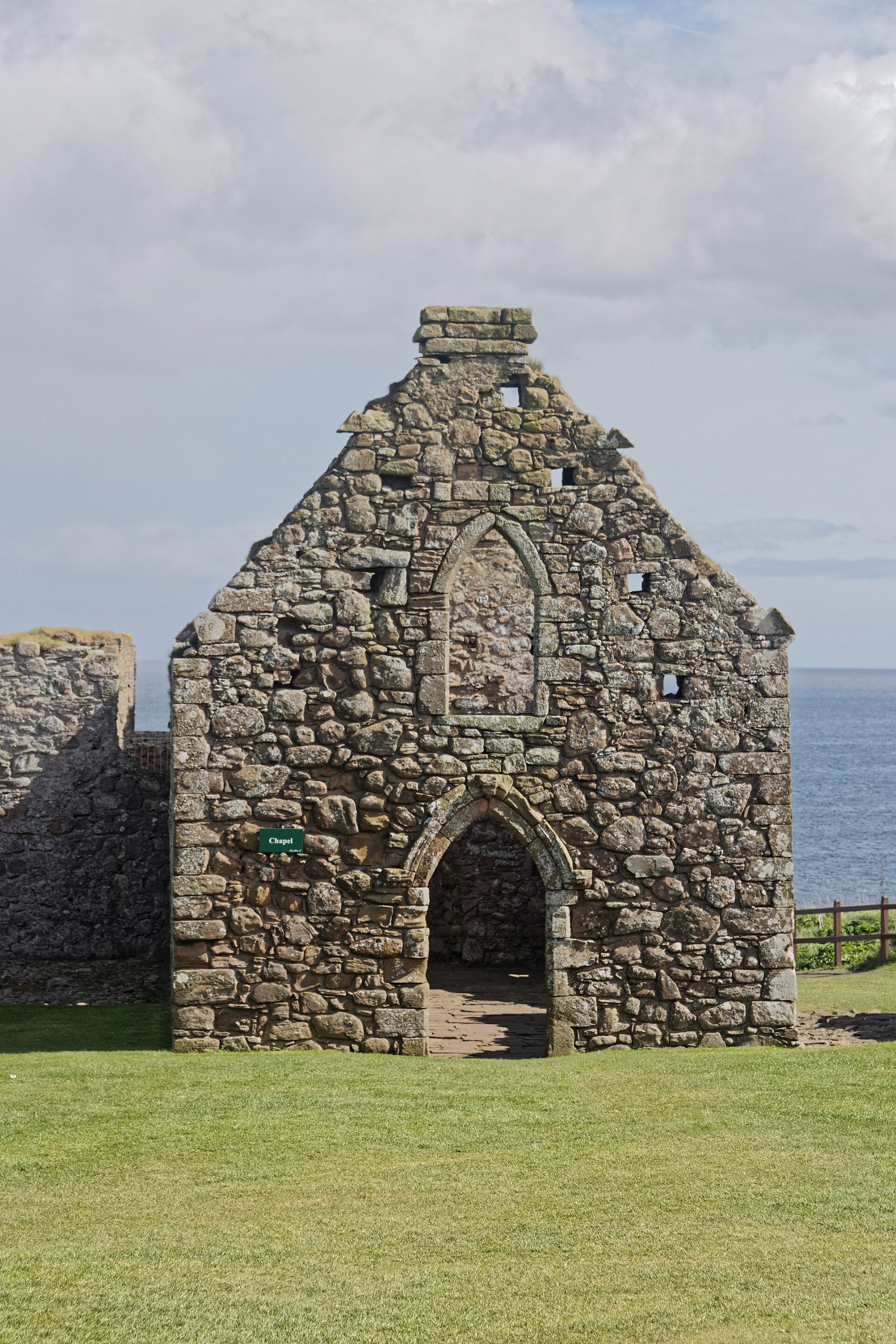 The tower house and buildings of the castle, seen across the rocky headland
