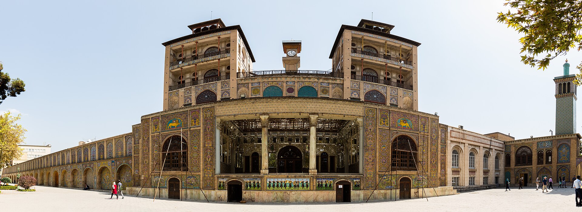 A panorama of the palace, its tiled facades glowing around the central garden.
