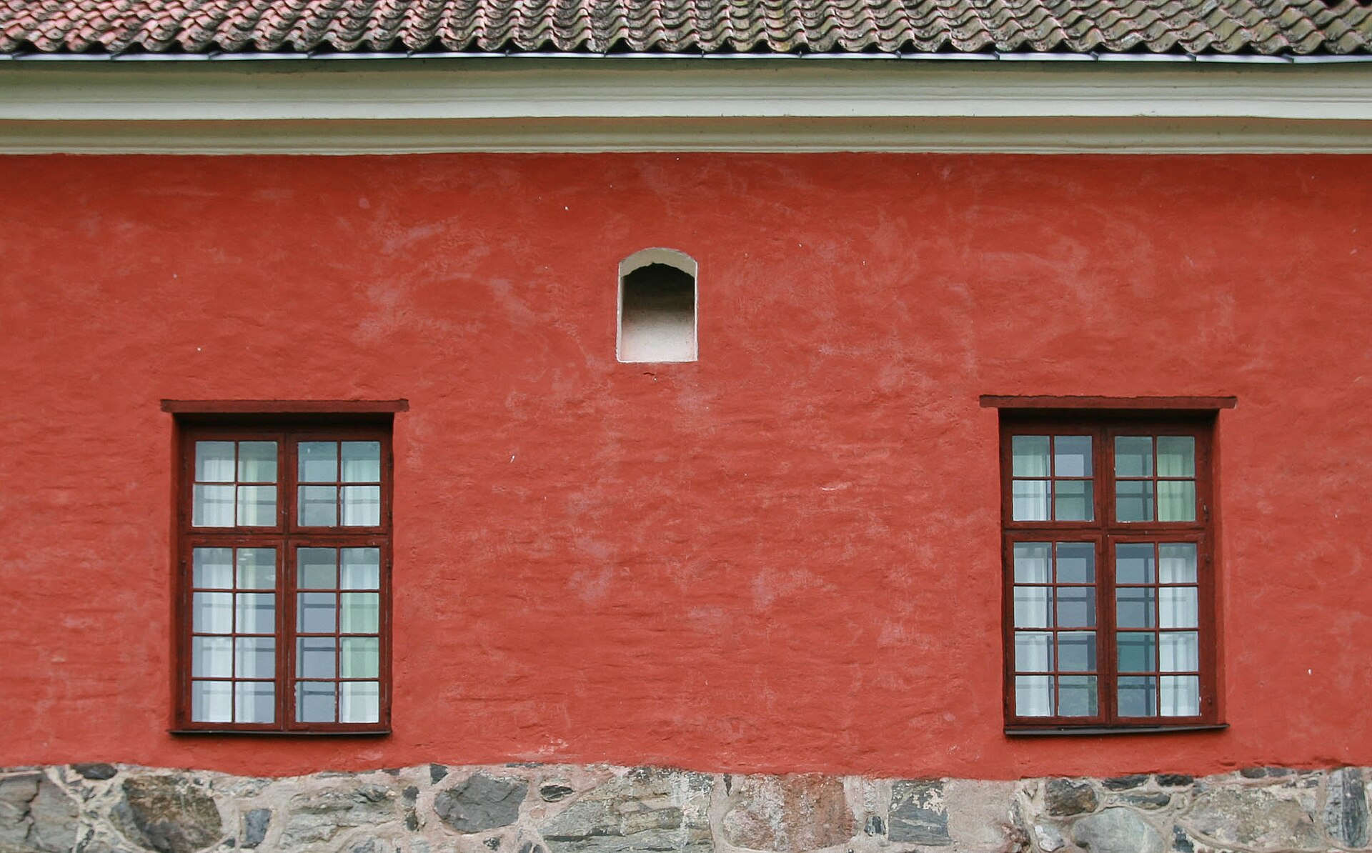 The warm red brick of the castle glows against the waters of the lake.