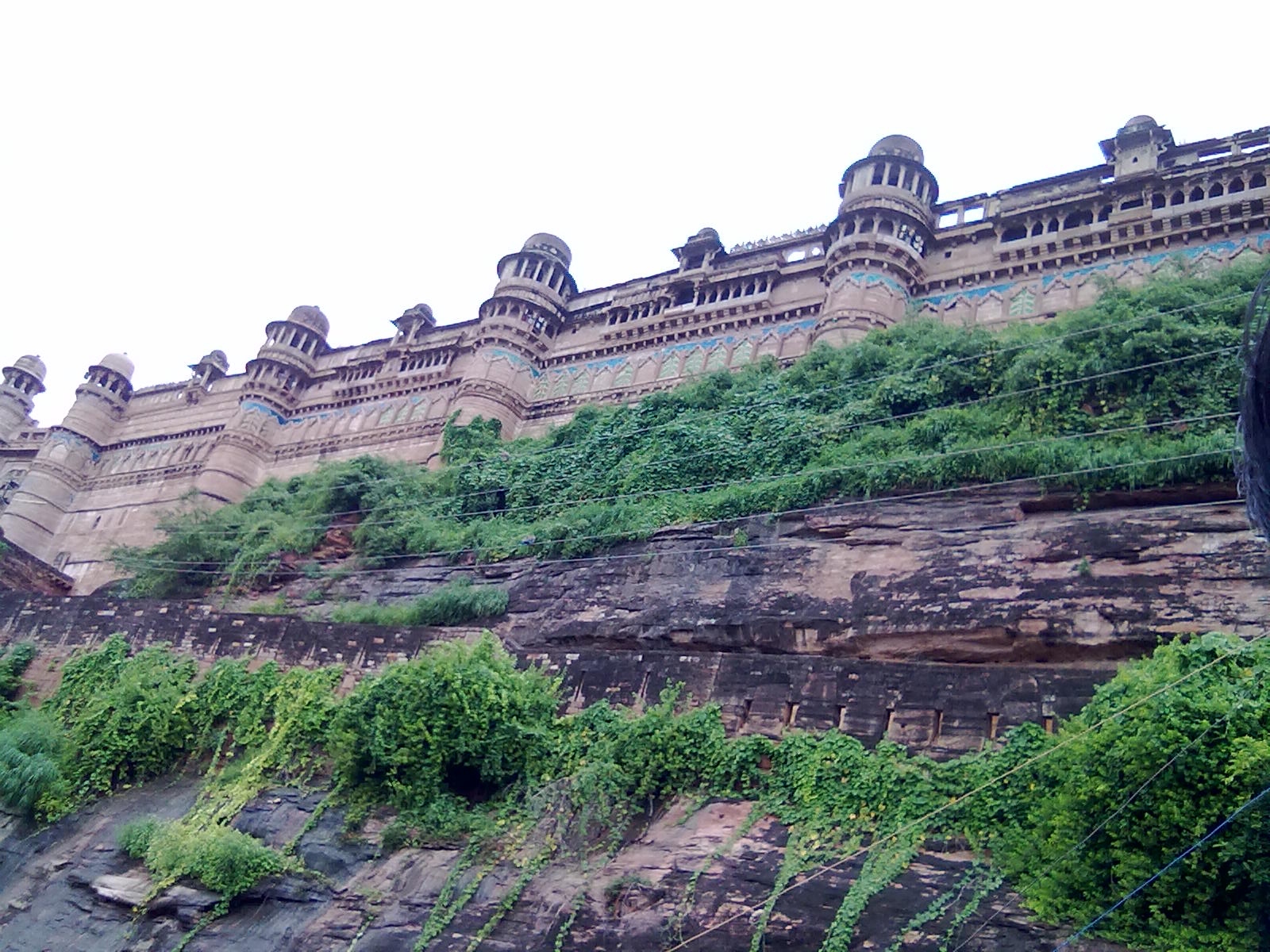 The Man Mandir's facade is adorned with brilliant blue, green, and yellow tile mosaics.