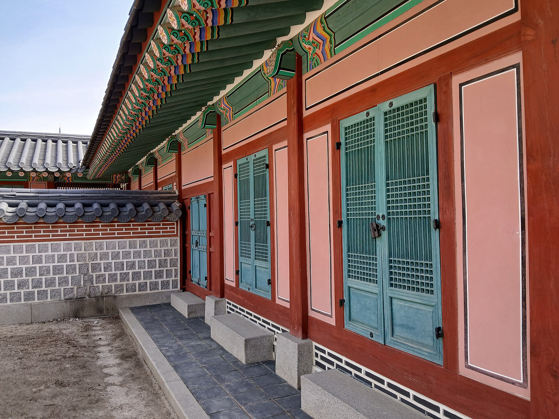 A hall of Gyeongbokgung, built of wood on a stone platform with a gracefully curving roof.