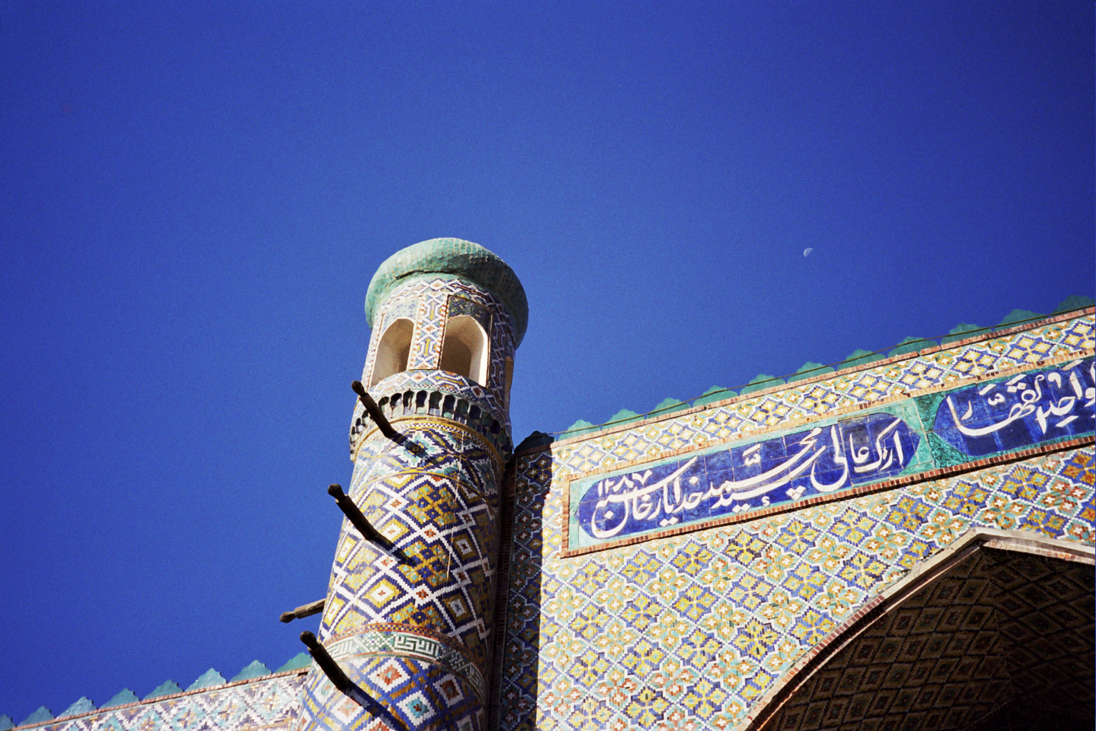 Glazed tilework in blue, green, and gold covering the front of the palace