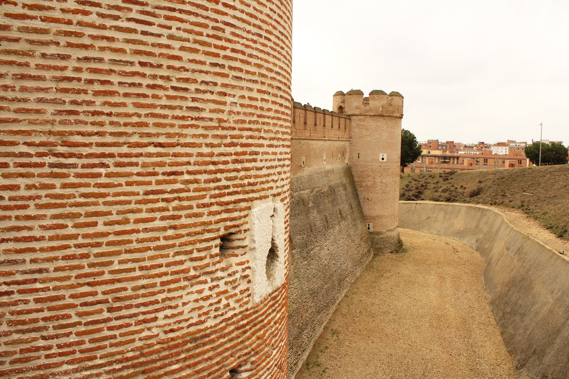 A broad, low outer wall pierced with gun loops marks la Mota as an early artillery fortress.