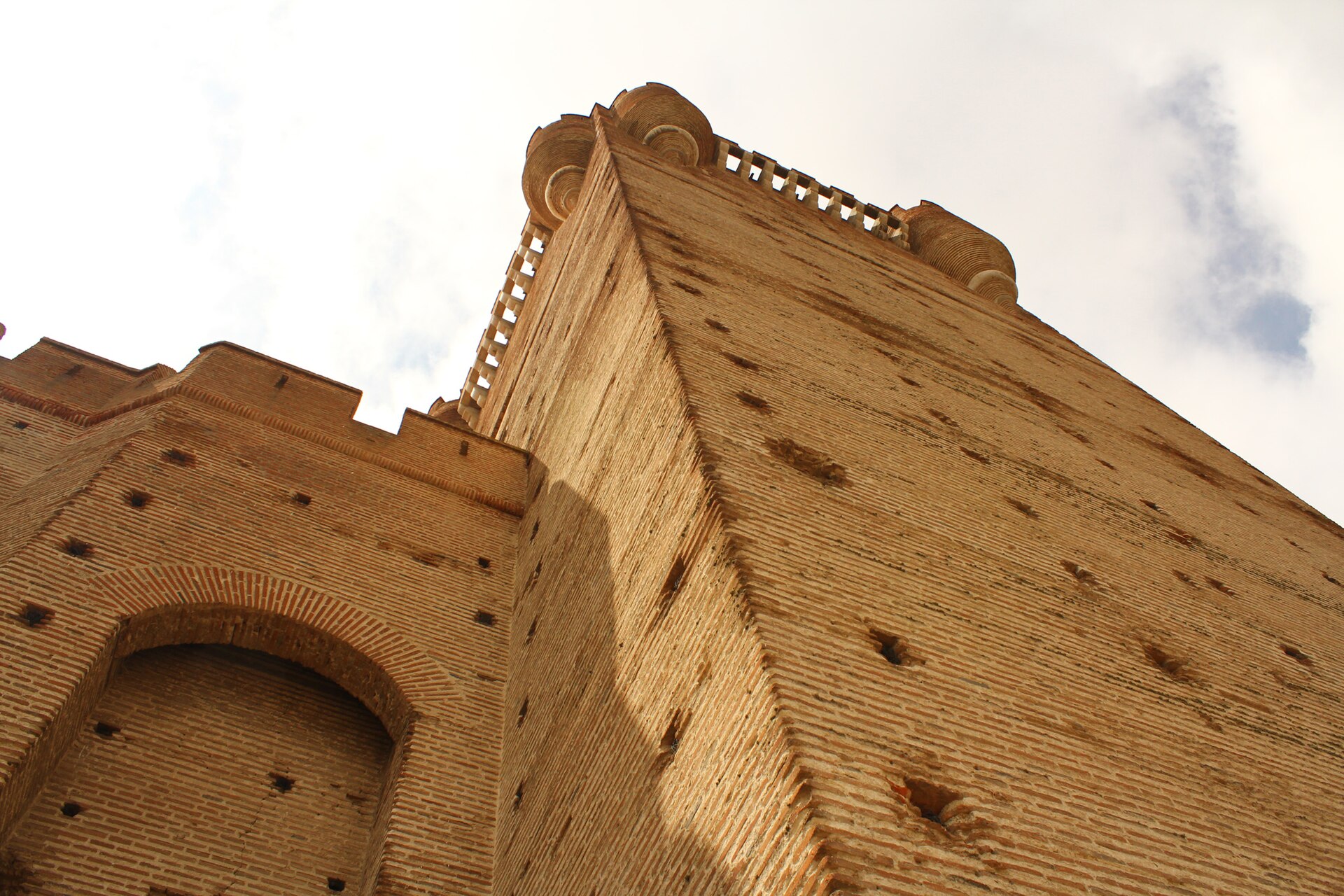 A deep moat, once crossed by a drawbridge, rings the great brick fortress.