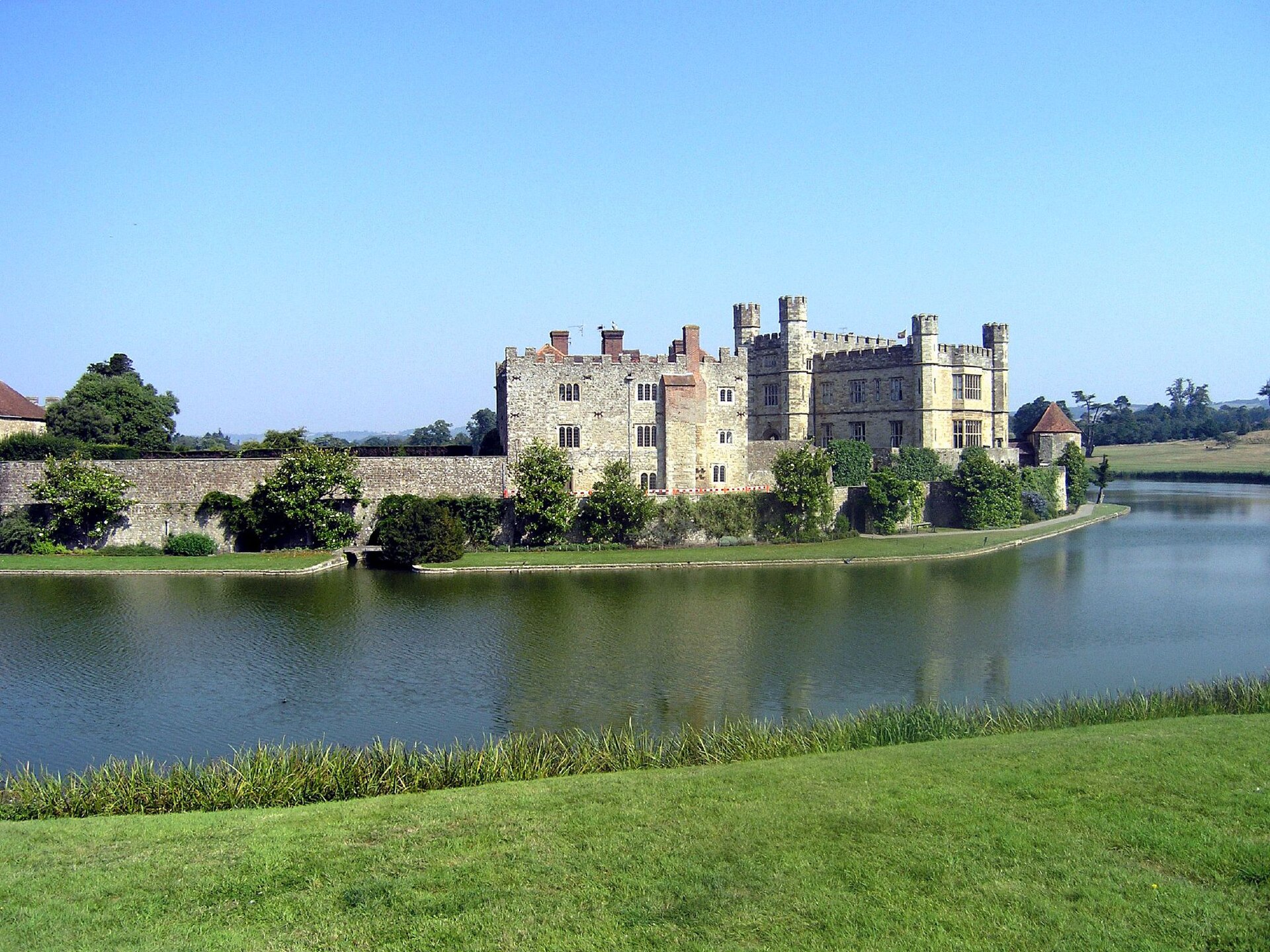 The castle seems to float on the water, its walls mirrored in the surrounding moat