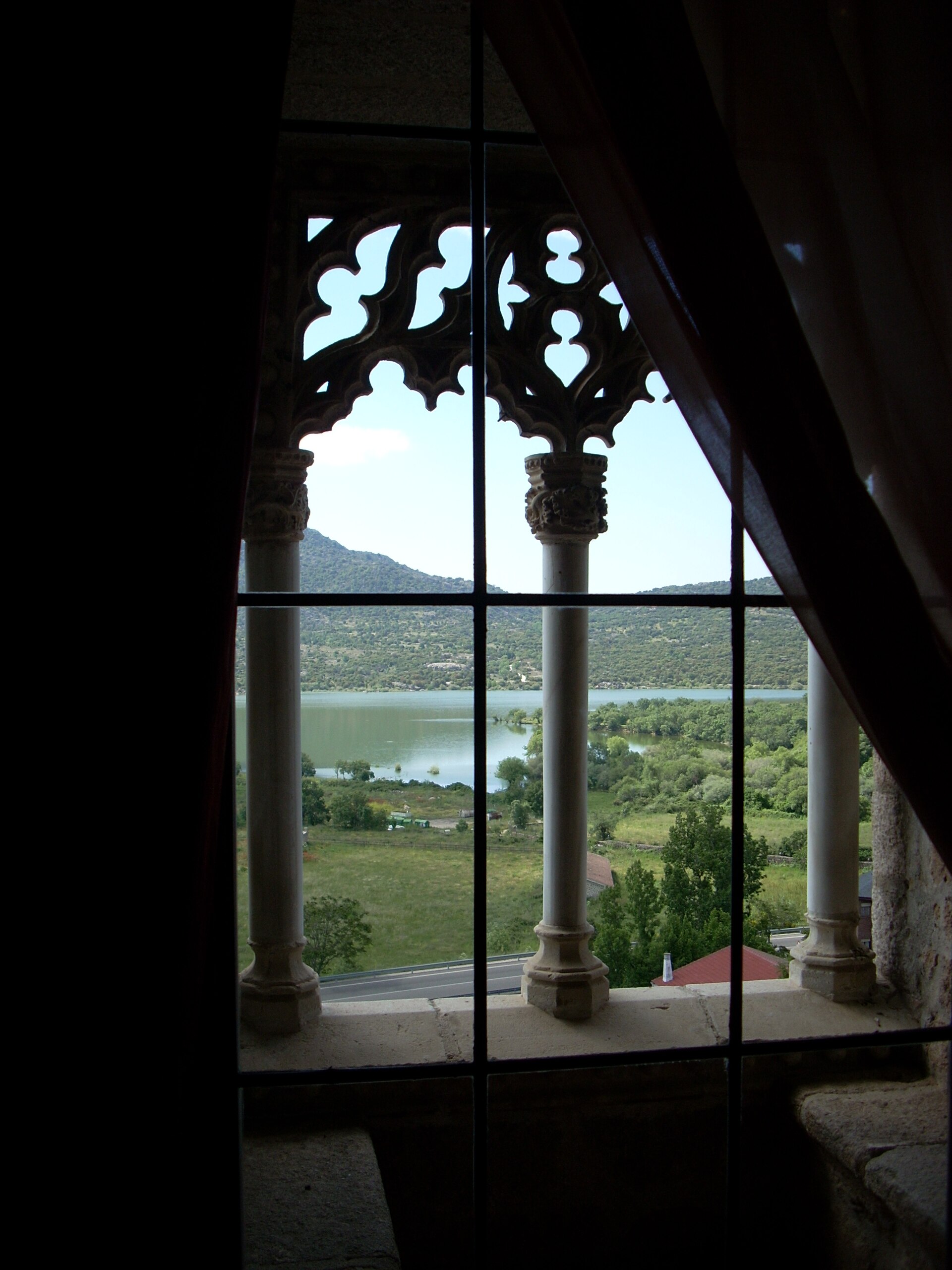 The castle stands against the dramatic granite backdrop of the Sierra de Guadarrama.