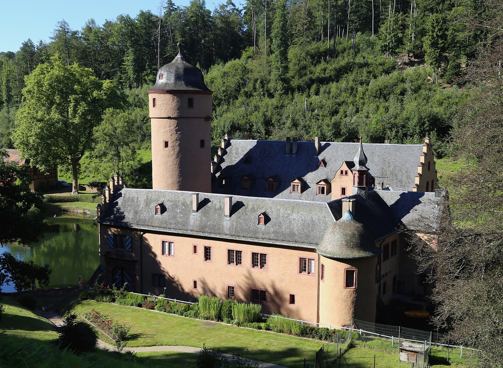 The castle among the trees, waiting at the end of the forest road