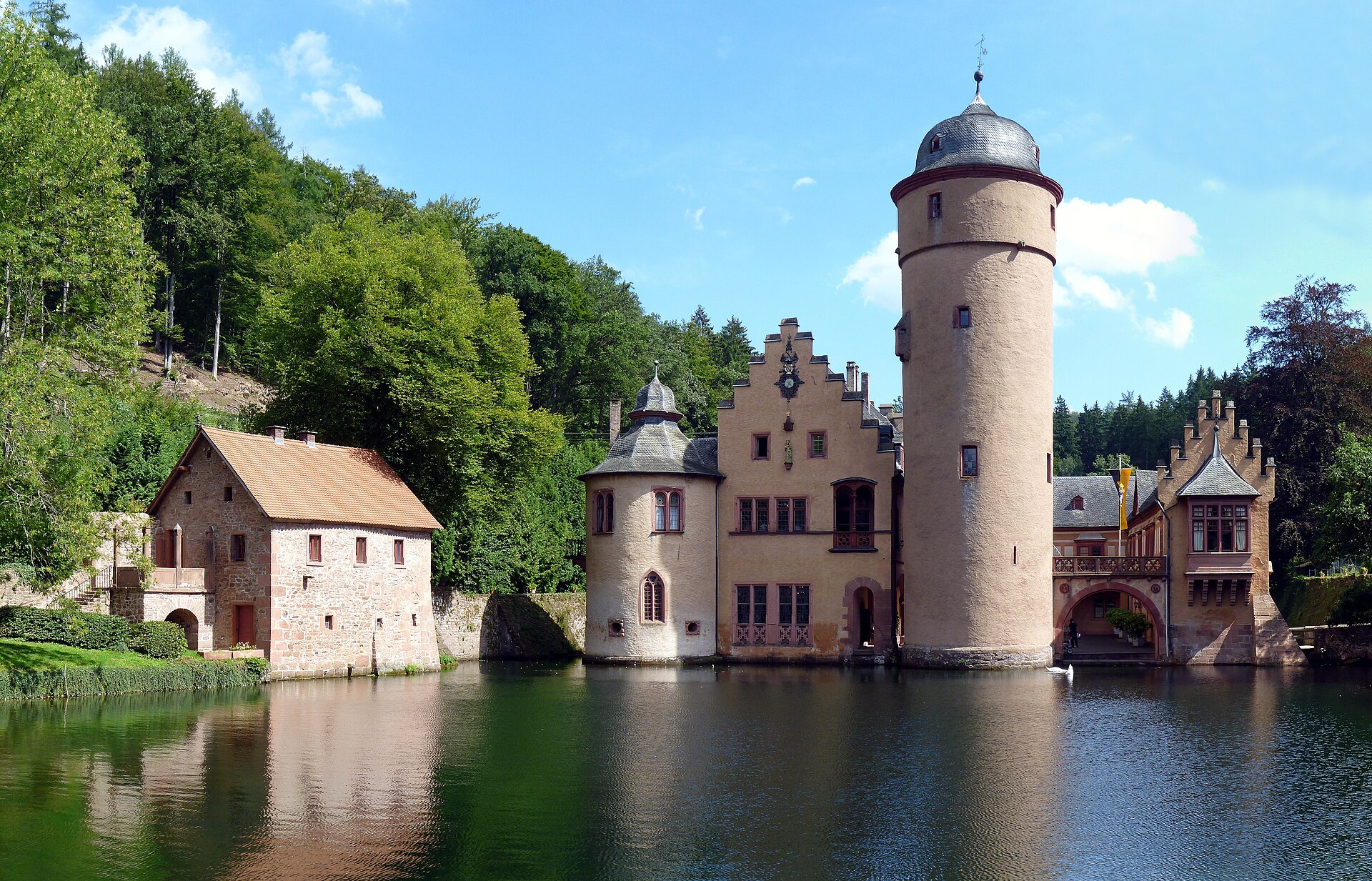 The moated castle rising from its still green pond