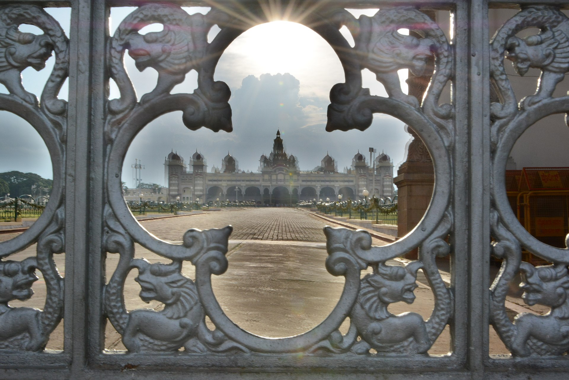 The palace rising above its gardens, approached through grand gates.