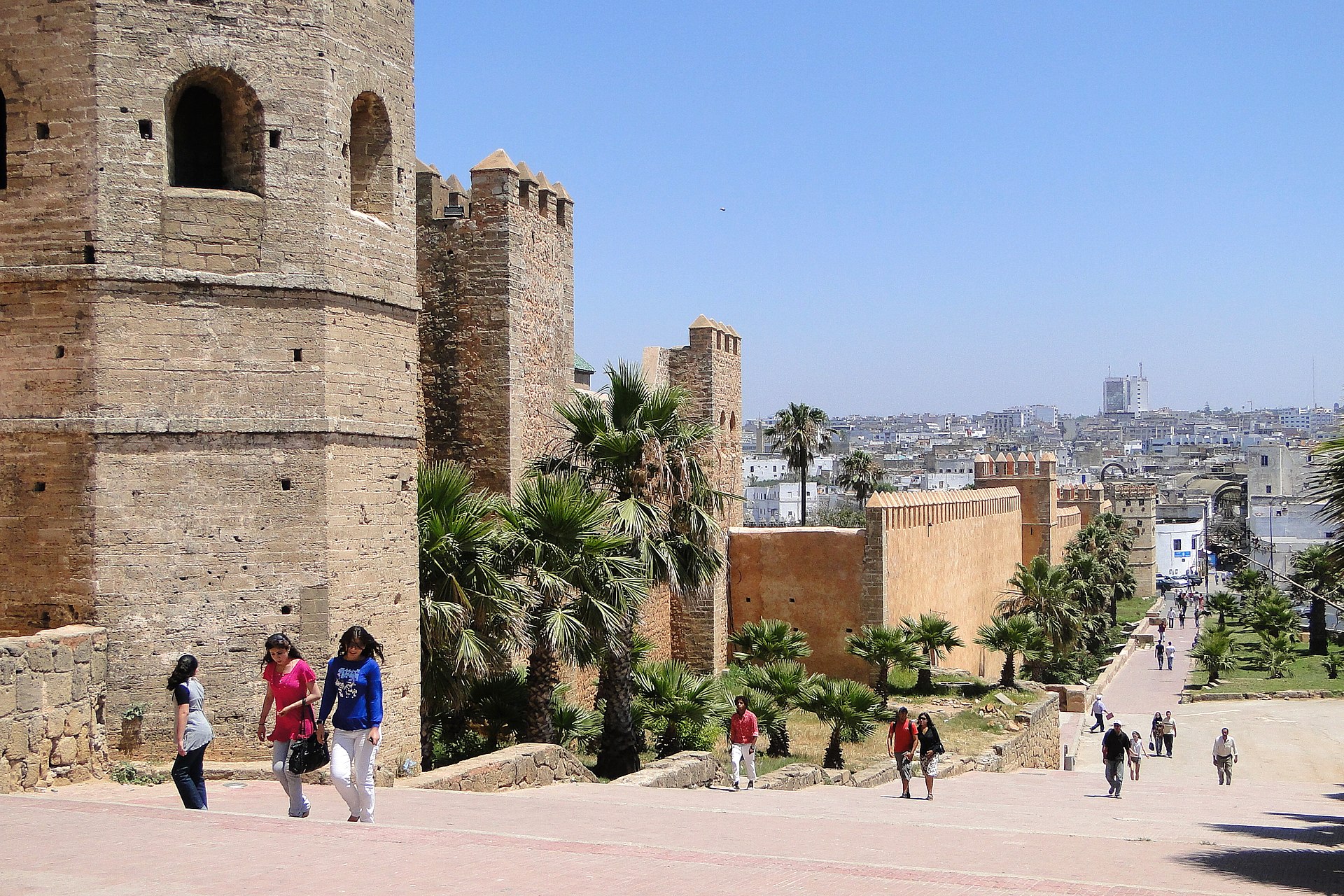 Pedestrians beside the towering walls of the kasbah