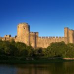 Pembroke Castle mirrored in the tidal river that wraps around its rock, the birthplace of a royal dynasty