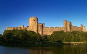 Pembroke Castle mirrored in the tidal river that wraps around its rock, the birthplace of a royal dynasty