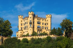 Schloss Hohenschwangau glowing yellow against the Bavarian mountains