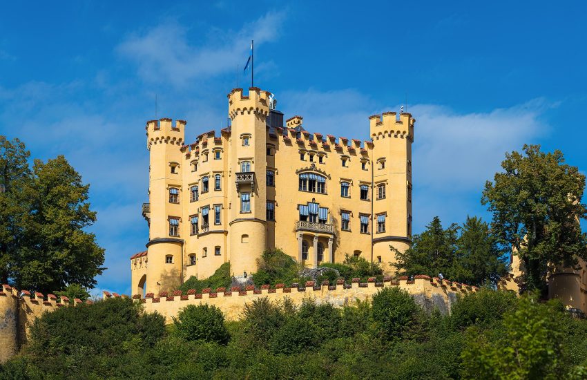 Schloss Hohenschwangau glowing yellow against the Bavarian mountains