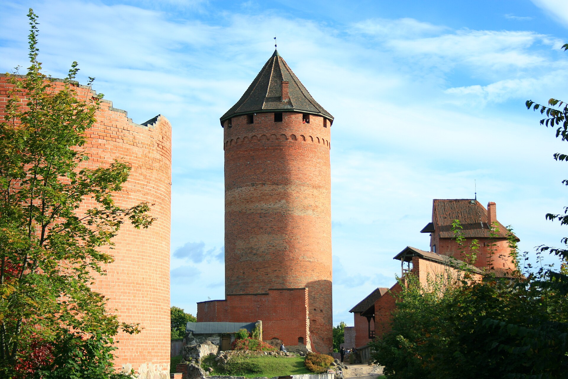 Turaida Castle rises in red brick above the green Gauja River valley in Latvia.