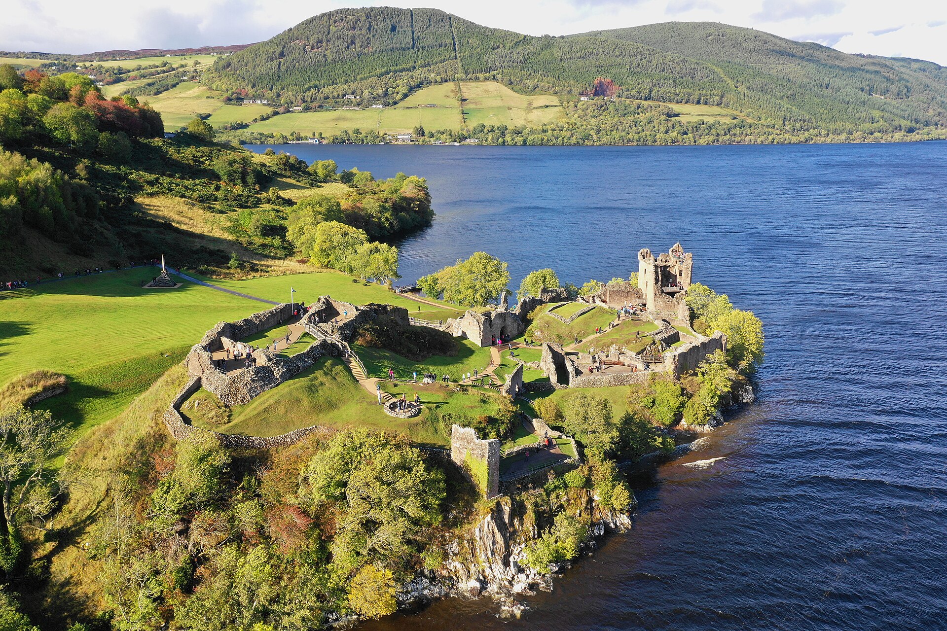 Urquhart from the air, its buildings strung out along a rocky promontory into Loch Ness