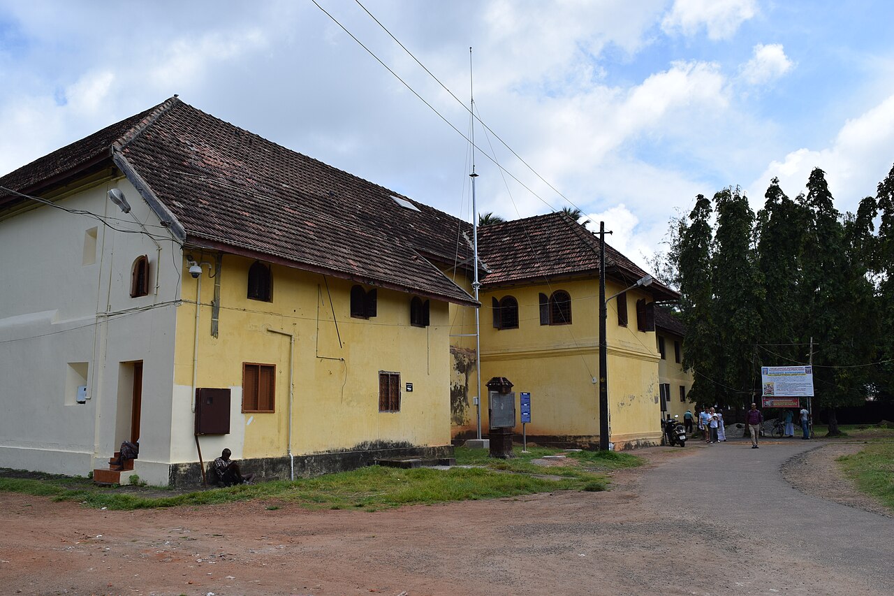The Mattancherry Palace facade in Kochi, a low white Portuguese-era building fronted by Kerala greenery
