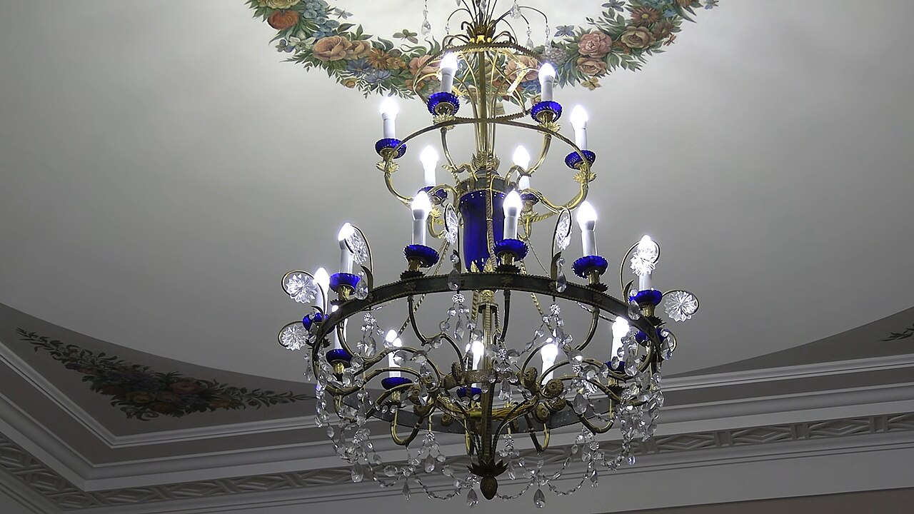 A gilded reception hall with chandeliers and mirrored walls